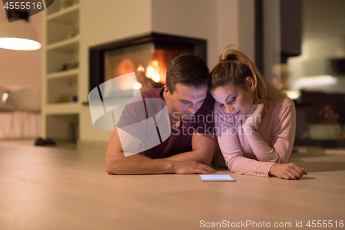 Image of Young Couple using digital tablet on cold winter night