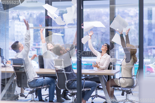 Image of startup Group of young business people throwing documents