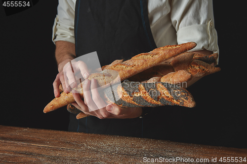 Image of Men\'s hands hold baguettes