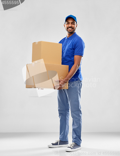 Image of happy indian delivery man with parcel boxes