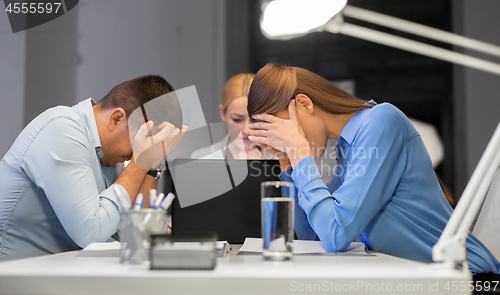 Image of business team with laptop working late at office