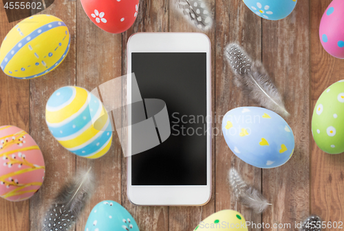 Image of smartphone with easter eggs and quail feathers