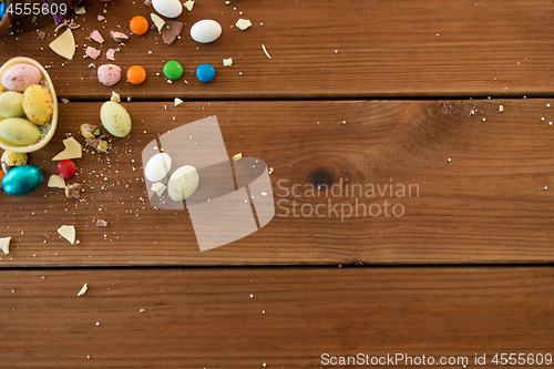 Image of chocolate eggs and candy drops on wooden table