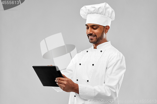 Image of happy male indian chef with tablet computer