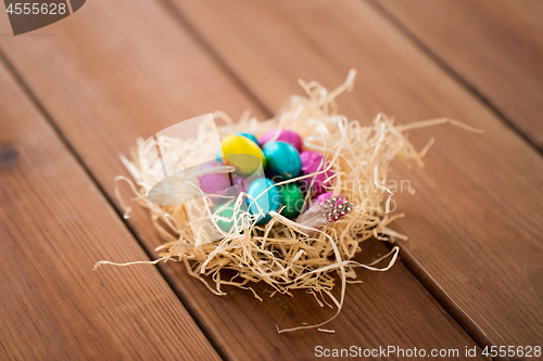 Image of chocolate easter eggs in straw nest on table