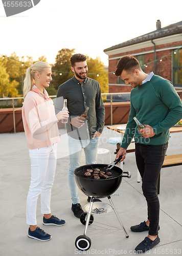 Image of happy friends having bbq party on rooftop