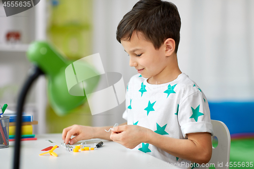 Image of little boy playing with building kit at home