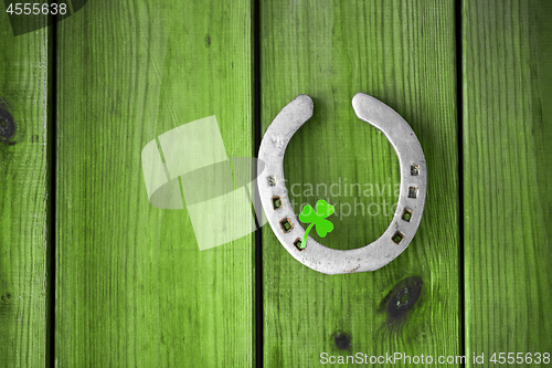 Image of horseshoe with shamrock on green wood boards