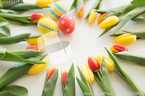 Image of close up of colored easter eggs and tulip flowers