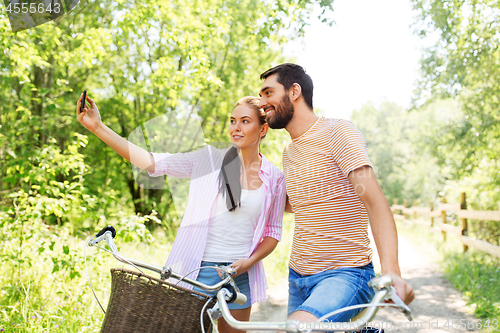 Image of couple with bicycles taking selfie by smartphone