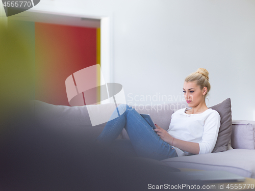 Image of woman on sofa using tablet computer