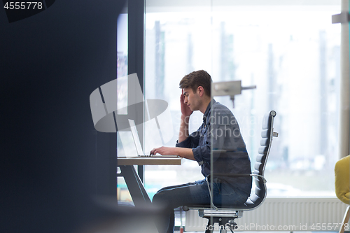 Image of businessman working using a laptop in startup office