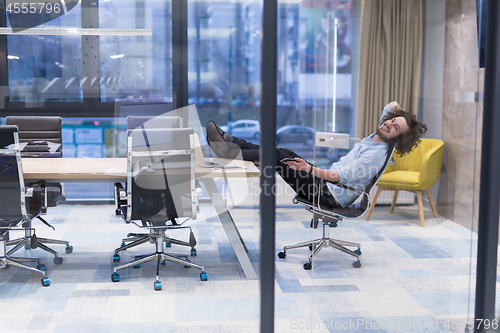 Image of young businessman relaxing at the desk