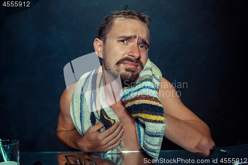 Image of Close up photo of young man looking for acnes on his face