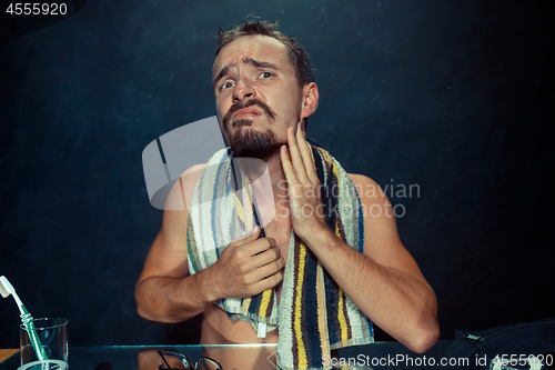 Image of Close up photo of young man looking for acnes on his face