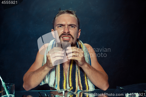 Image of Close up photo of young man looking for acnes on his face