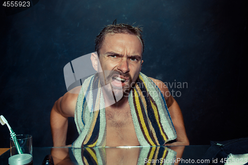 Image of Close up photo of young man looking for acnes on his face