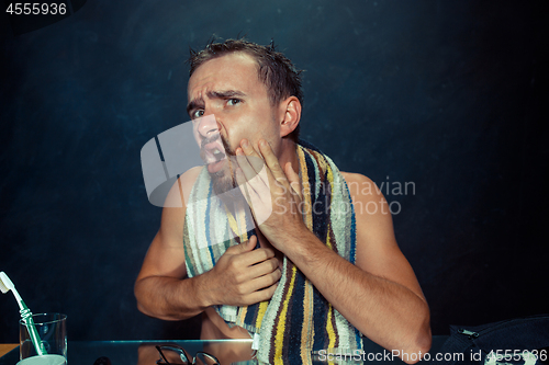 Image of Close up photo of young man looking for acnes on his face