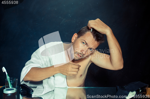 Image of Man With Comb Concerned About Hair Loss