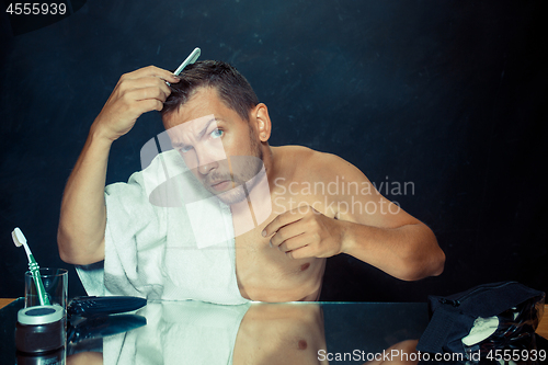 Image of Man With Comb Concerned About Hair Loss