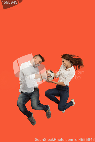 Image of The young man and woman as soccer football players kicking the ball at studio