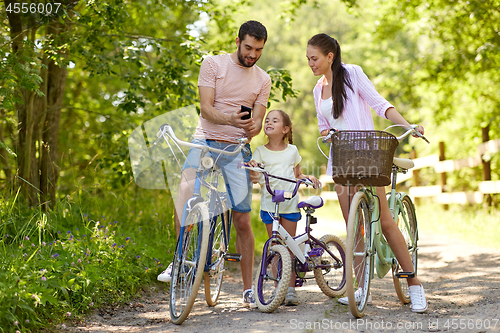 Image of family with smartphone and bicycles in summer park