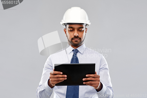 Image of architect or businessman in helmet with tablet pc