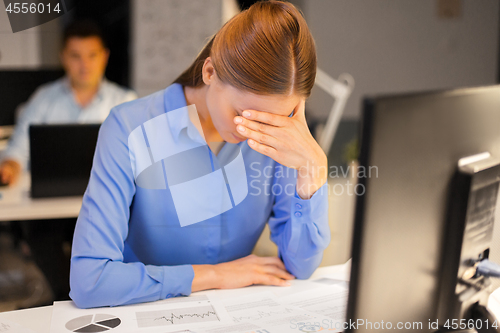 Image of businesswoman with computer at night office