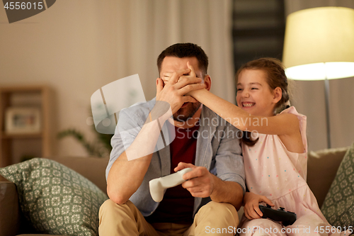 Image of father and daughter playing video game at home