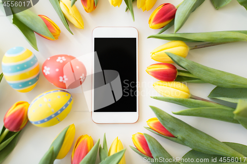 Image of smartphone with easter eggs and tulip flowers