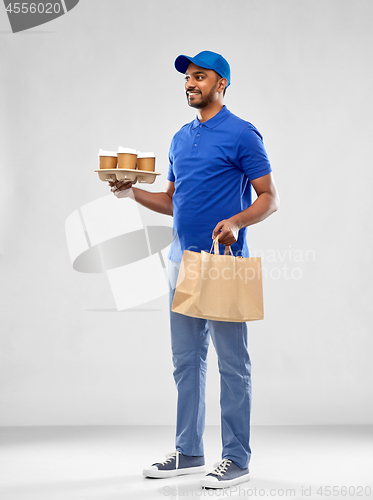 Image of happy indian delivery man with food and drinks