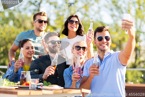 Image of happy friends taking selfie at rooftop party