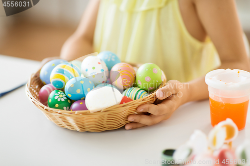 Image of close up of girl with easter eggs in wicker basket