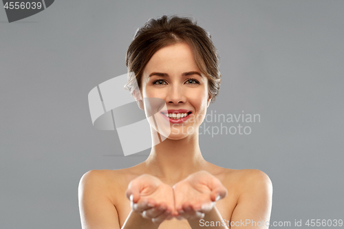 Image of smiling young woman holding something imaginary