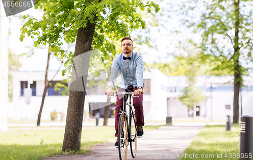 Image of happy young hipster man riding fixed gear bike