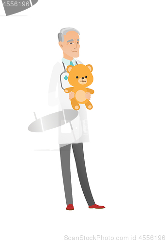 Image of Senior caucasian pediatrician holding teddy bear.
