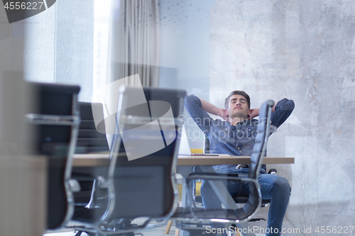 Image of young businessman relaxing at the desk