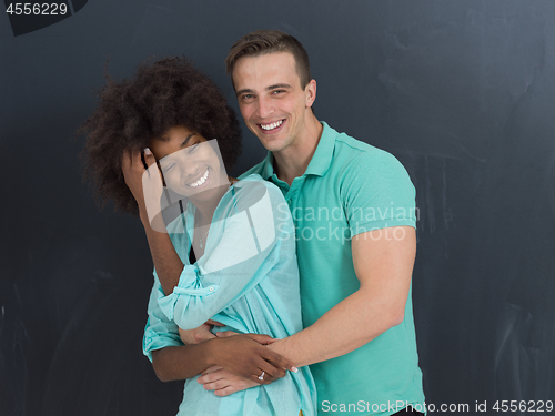 Image of multiethnic couple in front of gray chalkboard