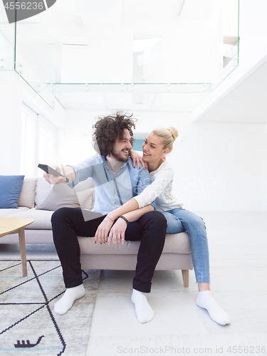 Image of Young couple on the sofa watching television