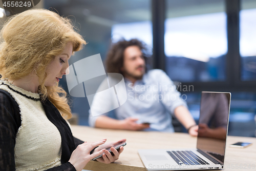 Image of Elegant Woman Using Mobile Phone in startup office building