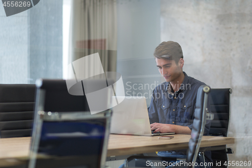 Image of businessman working using a laptop in startup office