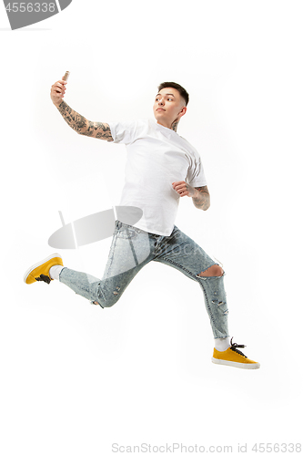 Image of Full length of handsome young man taking selfie while jumping