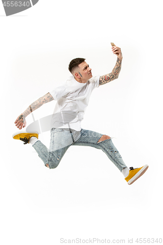 Image of Full length of handsome young man taking selfie while jumping