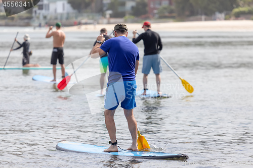 Image of men paddling in the ocean