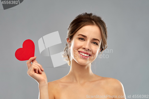 Image of beautiful smiling woman holding red heart