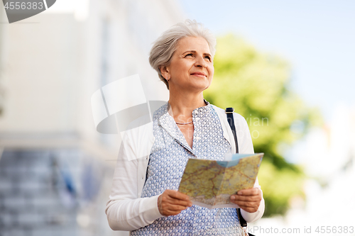 Image of senior woman or tourist with map on city street