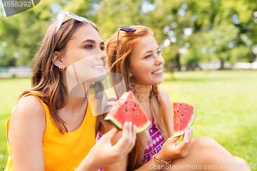 Image of teenage girls eating watermelon at picnic in park