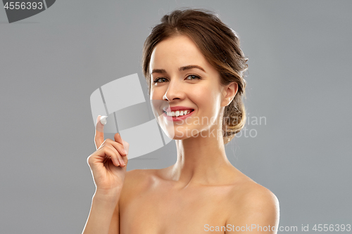 Image of happy young woman with cream on her finger