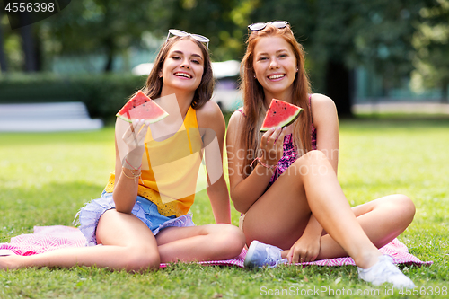 Image of teenage girls eating watermelon at picnic in park