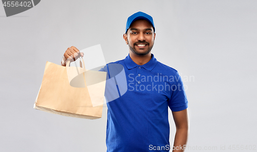 Image of happy indian delivery man with food in paper bag